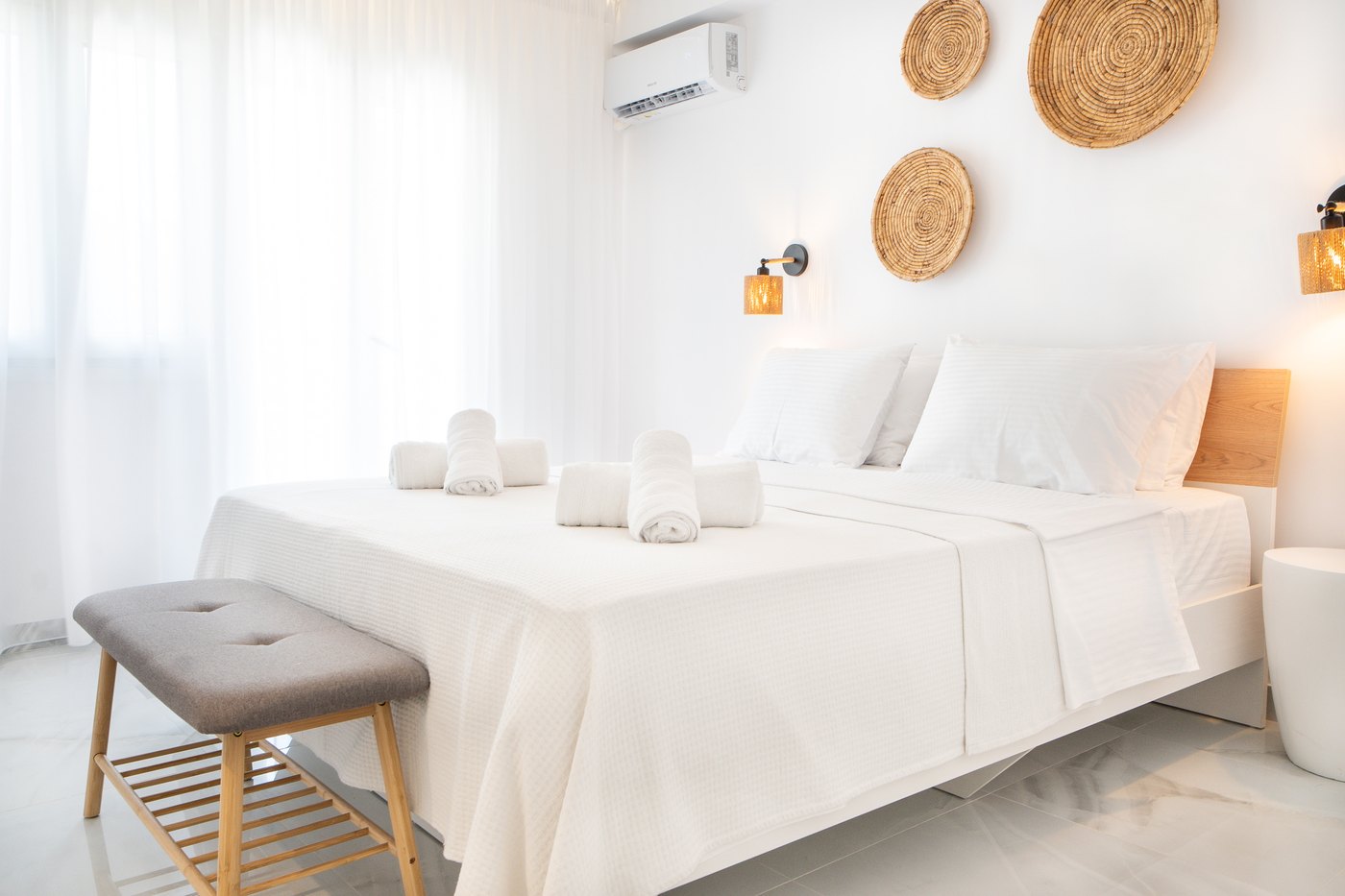 Tourkopazaro Aura bedroom with white linens and woven heritage details